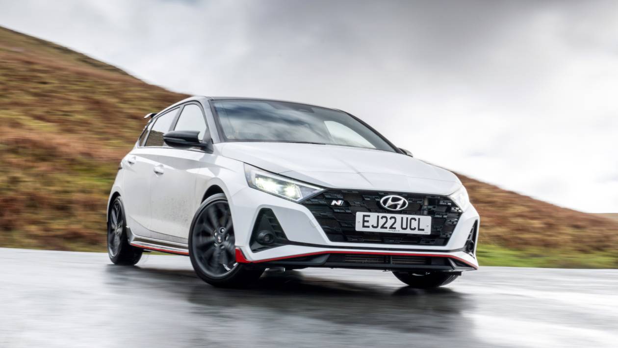 Hyundai i20 N front three-quarter view in Performance Blue showing aggressive N body kit and 18-inch anthracite wheels